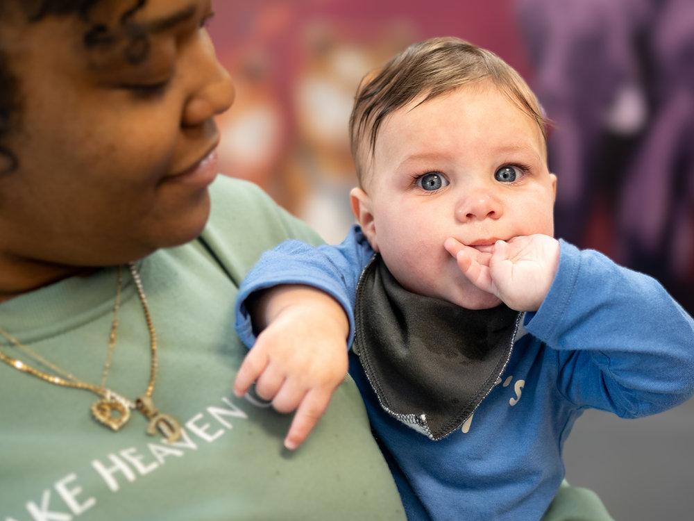 Teacher smiling at a baby in the infant daycare room at Victory Academy in Raleigh NC