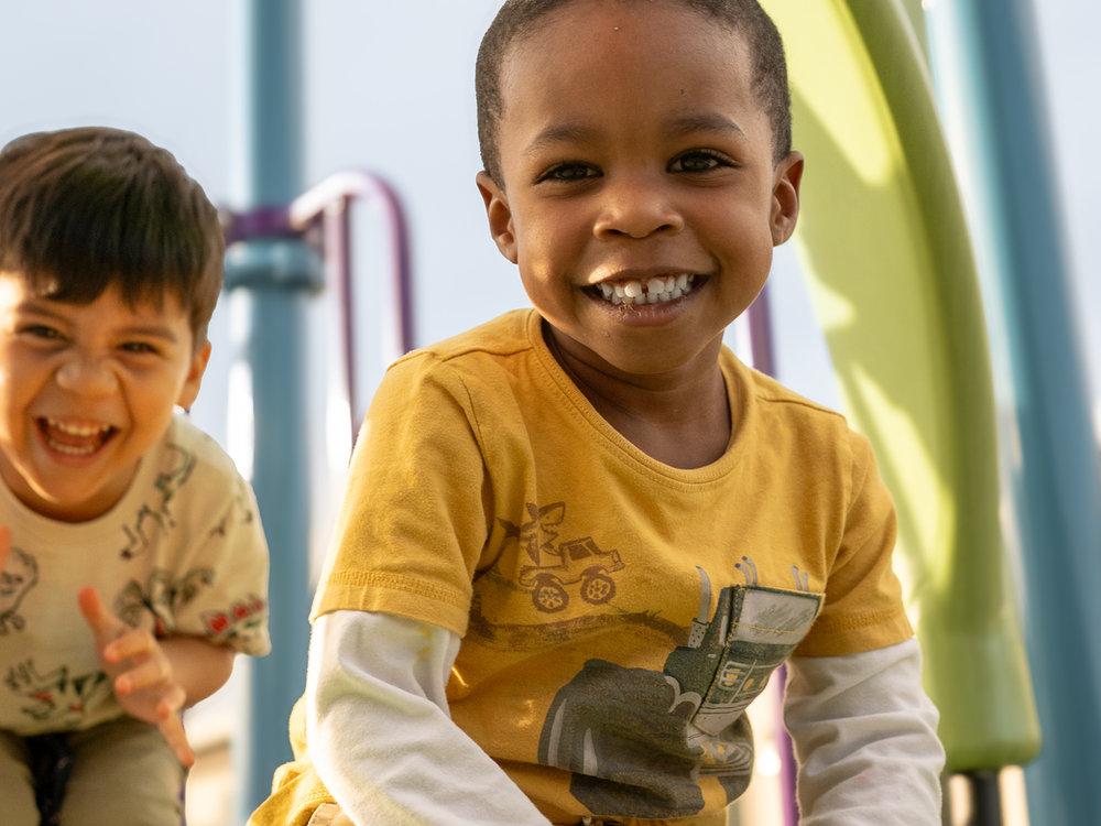 Preschool friends laughing on the playground at Victory Academy in Raleigh NC